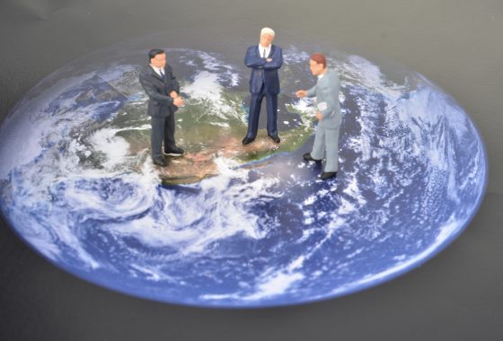 miniature men on world map