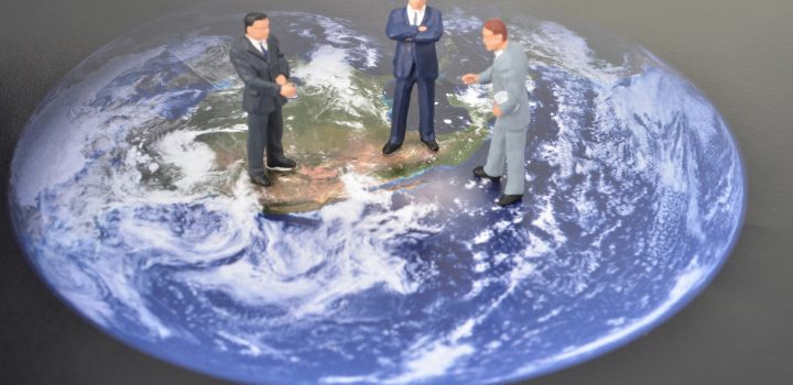miniature men on world map